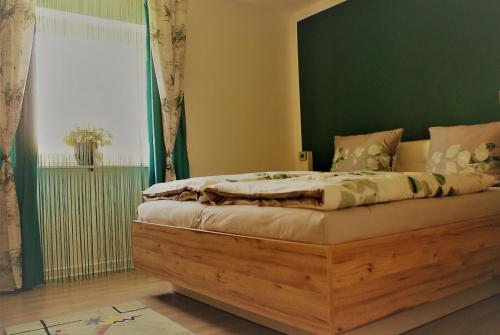 1 dormitorio con cama de madera y pared verde en FeWo Marktheidenfeld, en Marktheidenfeld