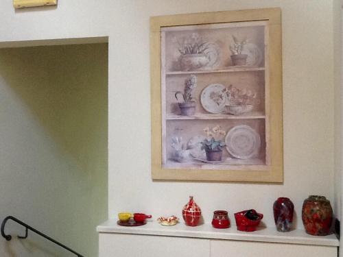 a shelf with plates and vases on a wall at Hostaria Da Ivan in Roccabianca