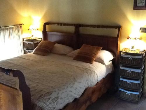 a bedroom with a large wooden bed with two night stands at Hostaria Da Ivan in Roccabianca