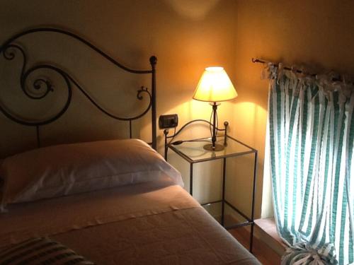 a bedroom with a bed with a lamp and a window at Hostaria Da Ivan in Roccabianca