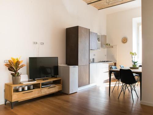 a living room with a television and a table with chairs at Domus Claudi Colosseum in Rome