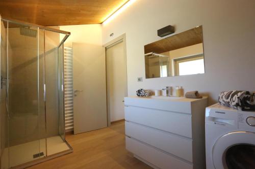a bathroom with a shower and a washing machine at LA CASCINA DI CARLOTTA 1846 agriturismo in Alba