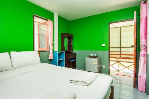 a green bedroom with a bed and a green wall at Sarm Mork Guest House in Mae Hong Son