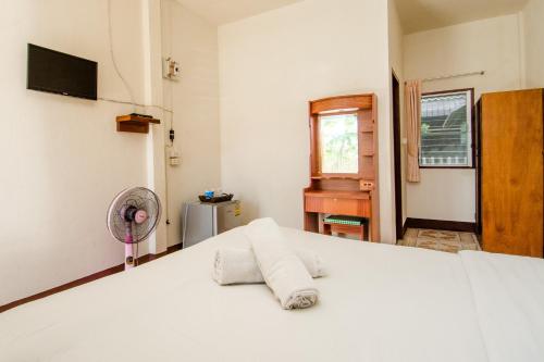 a bedroom with a white bed with a fan at Sarm Mork Guest House in Mae Hong Son
