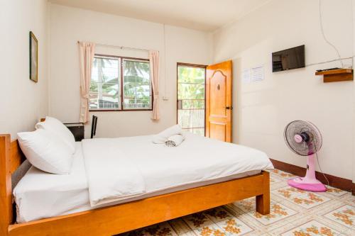 - une chambre avec un lit et un ventilateur dans l'établissement Sarm Mork Guest House, à Mae Hong Son