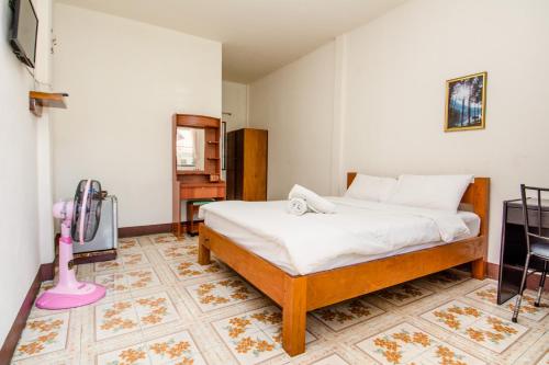 a bedroom with a bed and a tv in a room at Sarm Mork Guest House in Mae Hong Son