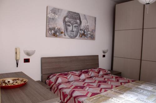 a bedroom with a bed with a painting on the wall at Porta del Carmine in Comacchio