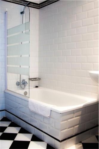 a white bathroom with a tub and a sink at Hotel Central Boutique in Marbella