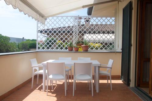 a patio with a table and chairs on a balcony at Appartamento con terrazza panoramica in Forte dei Marmi