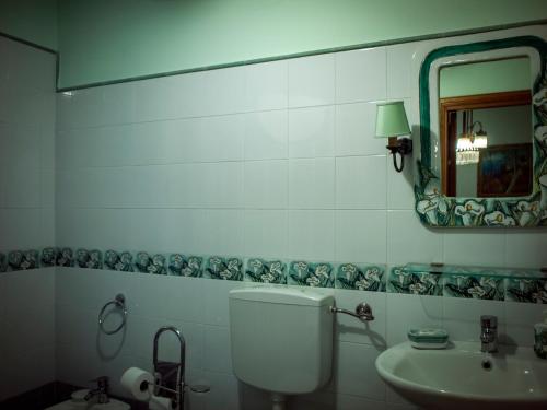 a bathroom with a toilet and a sink and a mirror at Guest House a Portapalermo in Santo Stefano di Camastra