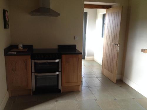 a kitchen with a stove and a counter top at Beech Farm Barn Annex in Worksop