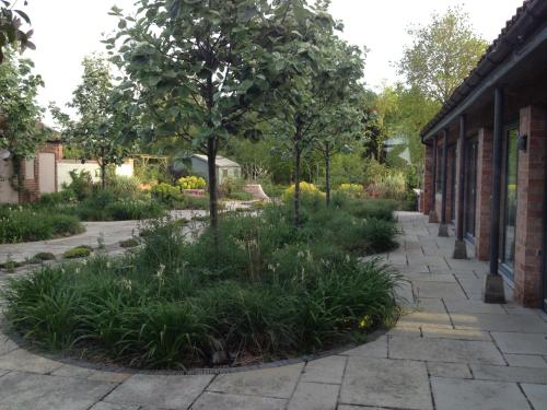 a garden with a tree in the middle of a sidewalk at Beech Farm Barn Annex in Worksop