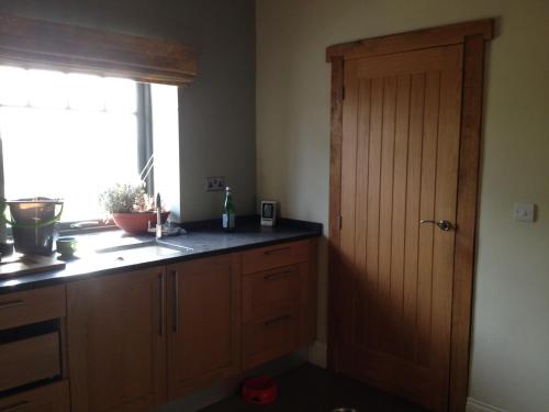 a kitchen with a window and a wooden cabinet at Beech Farm Barn Annex in Worksop