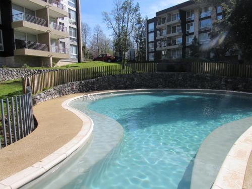 a swimming pool in front of a apartment building at Departamento en Pucon in Pucón