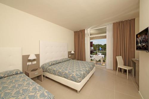 a hotel room with two beds and a television at Hotel Holiday in Sirmione