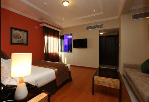 a hotel room with a bed and a couch at Park Jizan Hotel in Jazan