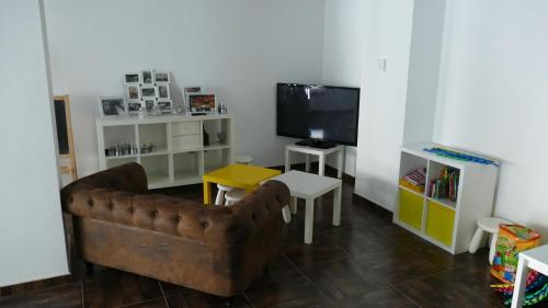 uma sala de estar com um sofá e uma televisão em Hotel Salomé em Calafell