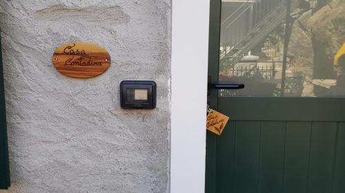 a wooden sign on a wall next to a door at Casa Contadina in Vercana