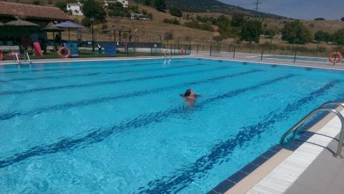 a person swimming in a swimming pool at Casa Sierra Norte Madrid in Lozoya