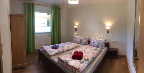 a bedroom with a bed with two shoes on it at Haus Astner in Aschau