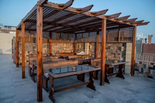 a wooden pavilion with benches and tables on a roof at Guardian Guest House in Cairo