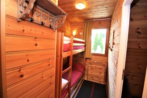 a bedroom with bunk beds in a wooden cabin at Chalet Deleglise 2 in Valfréjus