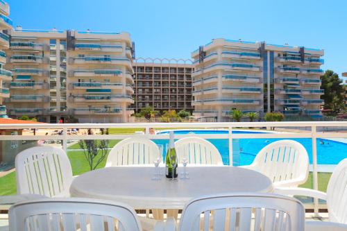 a white table and chairs on a balcony with buildings at UHC Larimar Family Complex in Salou