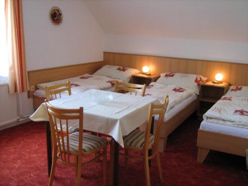 ein Hotelzimmer mit 2 Betten, einem Tisch und Stühlen in der Unterkunft Privát Kučera in Vysoké nad Jizerou