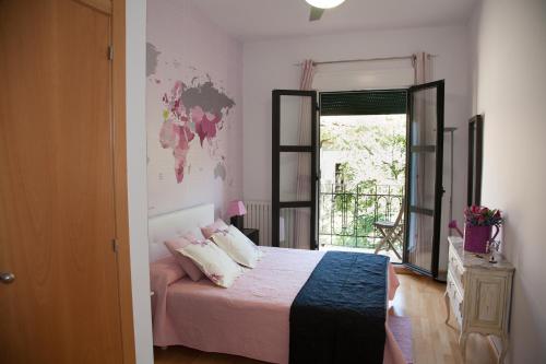 a bedroom with a bed with pink sheets and a window at Dean Dos Catedrales in Zaragoza