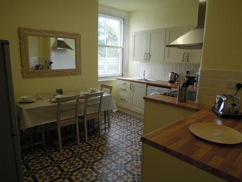 a kitchen with a table and a dining room at Special seafront apartment in Portsmouth