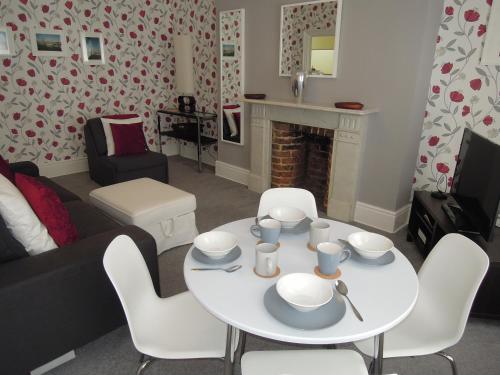 sala de estar con mesa blanca y sillas en Special seafront apartment en Portsmouth