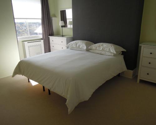 a bedroom with a white bed with pillows and a window at Special seafront apartment in Portsmouth