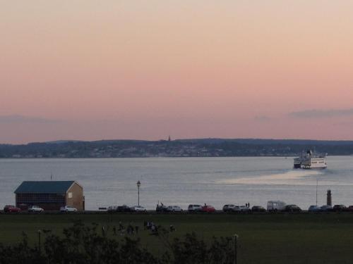 a large boat in the water at sunset at Special seafront apartment in Portsmouth
