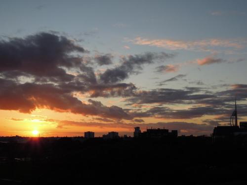a city skyline with the sunset in the background at Special seafront apartment in Portsmouth