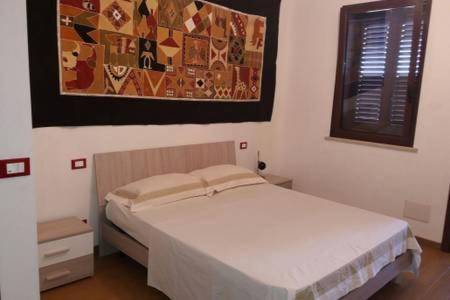 MartignanoにあるDa Zio Antonio - Vacanze nel Salentoのベッドルーム1室(ベッド1台付)が備わります。壁に絵が飾られています。