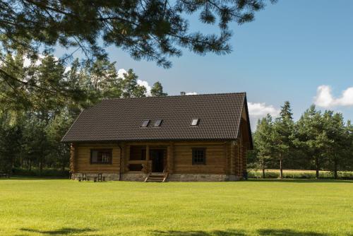 une cabane en rondins dans un champ d'herbe verte dans l'établissement Pinnamäe Holiday House, à Partsi