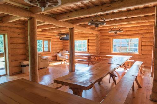 a dining room with a large wooden table in a log cabin at Pinnamäe Holiday House in Partsi