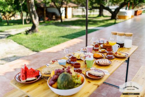 a table with food and drinks and a bowl of fruit at Quinta da Saudade in Ponte de Sor