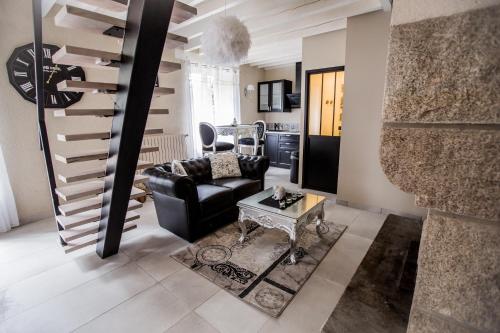 a living room with a couch and a stair at Au domaine des anges, 3 gîtes luxueux avec Jacuzzi privatif, sauna, mini-piscine, piscine extérieure chauffée en saison in Bain-de-Bretagne