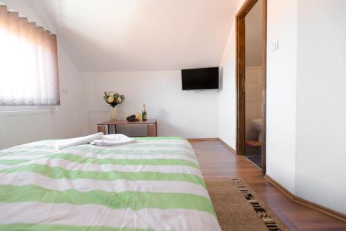 una camera con letto verde e bianco e specchio di Guesthouse Vila Puzic a Banja Luka