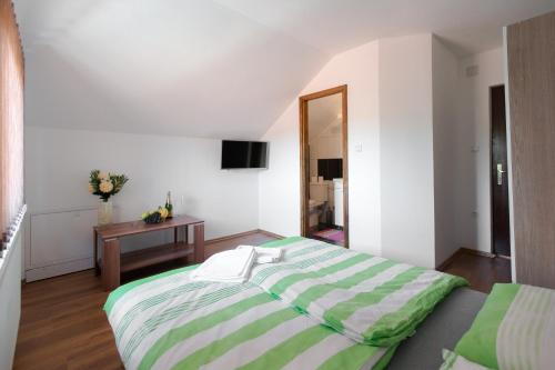 um quarto com uma cama grande e uma mesa em Guesthouse Vila Puzic em Banja Luka