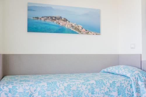 a bedroom with a bed with a painting on the wall at Hotel Holiday in Sirmione