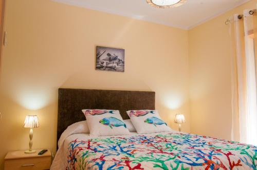 a bedroom with a bed and two pillows at Pilot House - Village Marina in Olhão