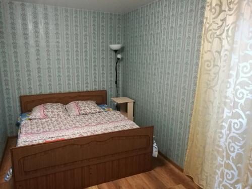 クルガンにあるV tsentre apartmentsの緑の壁紙のベッドルーム1室(ベッド1台付)