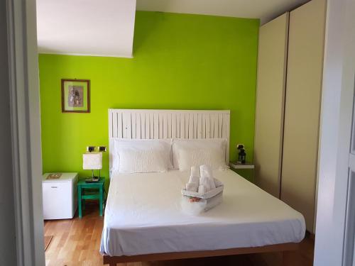 una camera da letto con un letto bianco e pareti verdi di B&B Albaluna a Valenzano