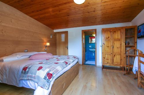 a bedroom with a bed and a wooden wall at Albergo Adele in Bormio