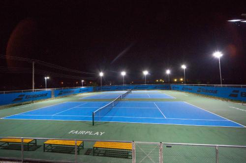 a tennis court at night with lights on at Athina Airport Hotel in Thérmi