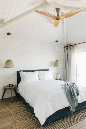 a bedroom with a white bed and a ceiling fan at The Surfrider Malibu in Malibu
