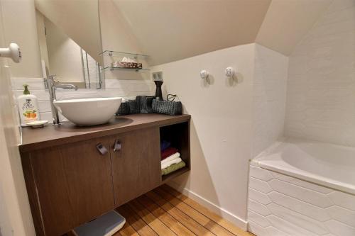 W łazience znajduje się umywalka i wanna. w obiekcie Deauville Paradise w mieście Deauville