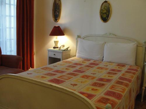 a bedroom with a bed and a lamp and a phone at Hotel Casa Gonzalez in Mexico City